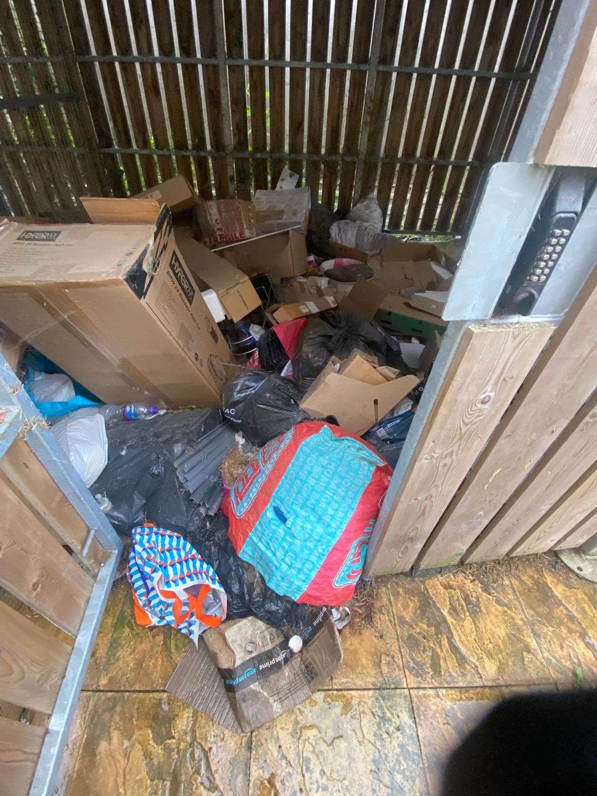 Communal bin store completely full of waste before clearance