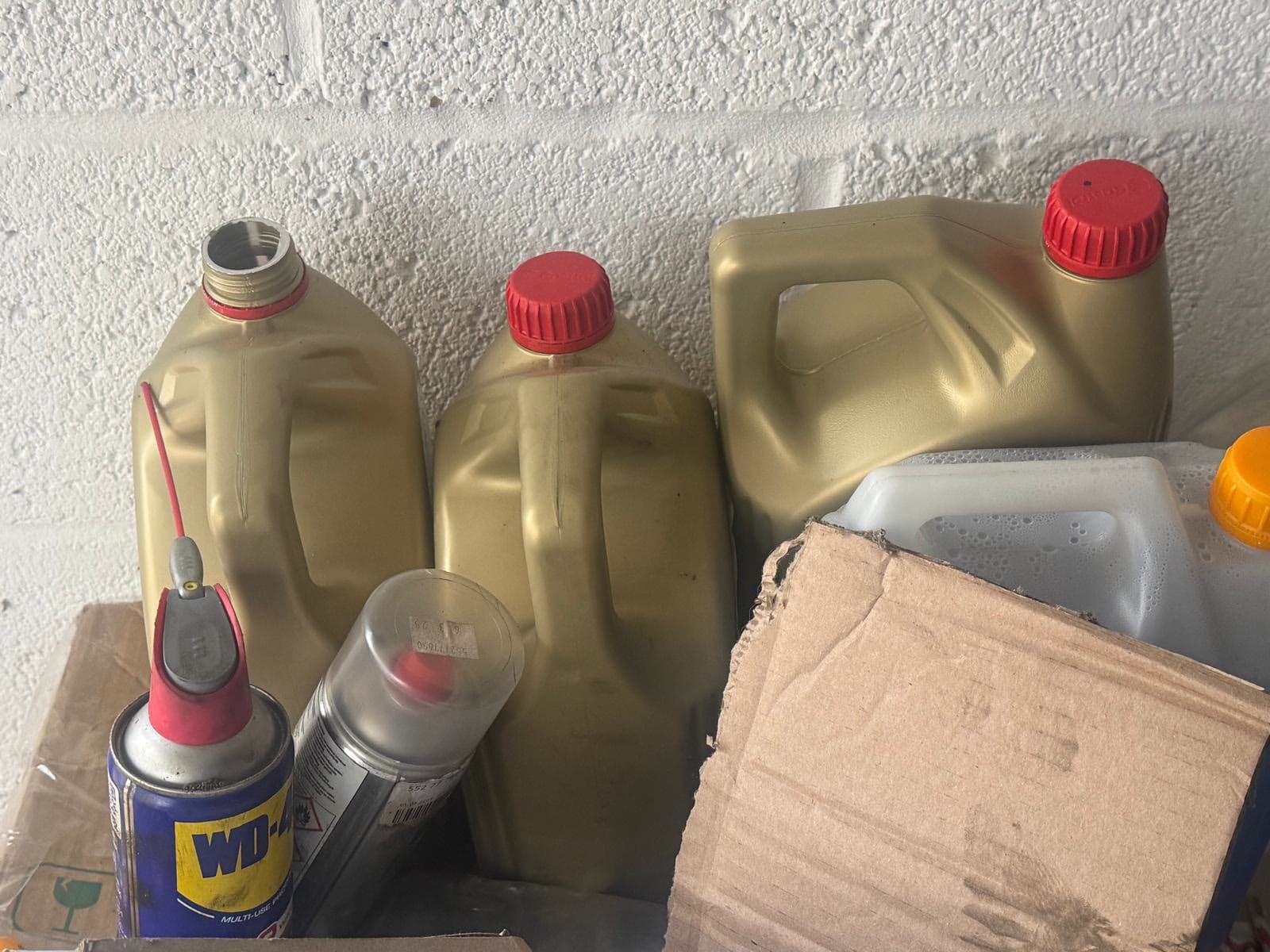 Used engine oil containers and car fluids collected for responsible disposal