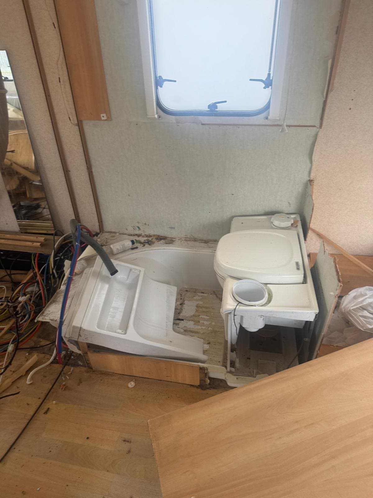 Caravan bathroom suite removed during an interior strip-out